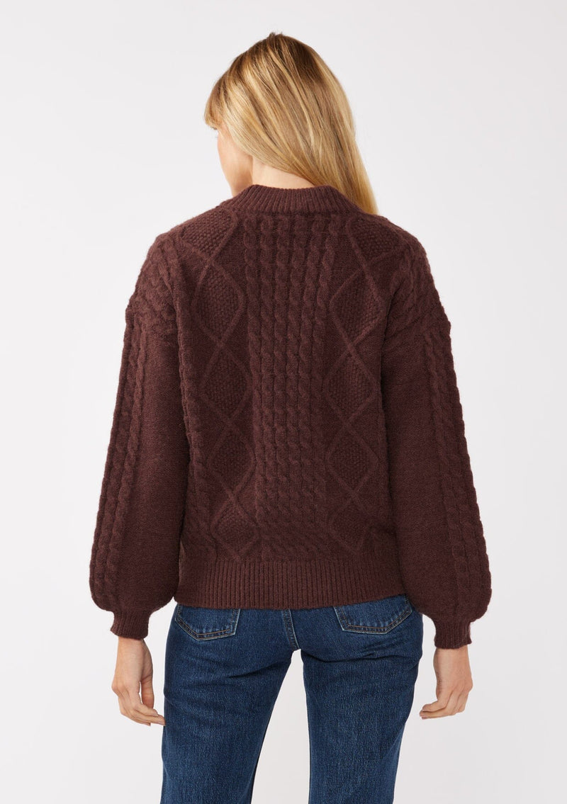 [Color: Dark Brown] A blonde model wearing an brown cozy knit sweater with a zipper front. Featuring long sleeves and classic ribbed trims. A versatile sweater perfect for layering and styling any fall ensemble. 