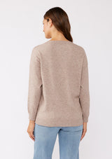 [Color: Heather Mocha] A back facing image of a brunette model wearing a casual light brown pullover sweater with tonal embroidery. This lightweight fall sweater features long sleeves, a classic round neckline, and rib trimming. 