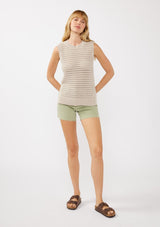 [Color: Mushroom] A front facing image of a blonde model wearing a sleeveless open knit sweater vest with a crew neckline, ribbed trim, and side slits. Perfect for layering over long sleeves or wearing on its own. 