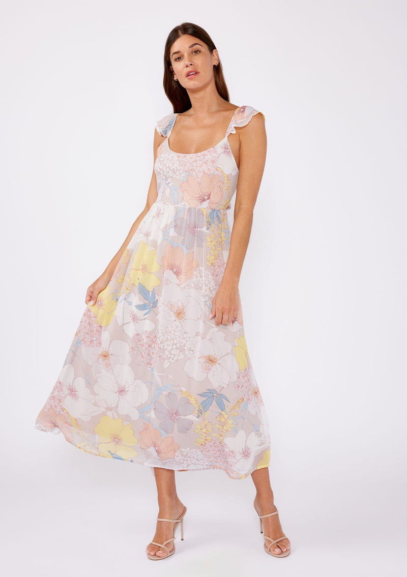 [Color: Natural/Blue] An image of a brunette model wearing a pretty chiffon spring maxi dress designed in a pink and blue floral print. With a slim fit bodice, short flutter cap sleeves, adjustable spaghetti straps, a flowy long skirt, a scooped neckline, and an open back detail with adjustable tie closure.