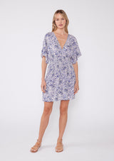 [Color: Bone/Lilac] Bohemian chic white mini dress with a deep v neckline, relaxed kimono sleeves and purple floral sketch print.