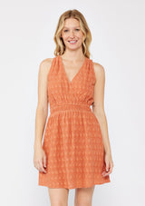 [Color: Terracota] A blonde model wearing a fall burnt orange mini dress with a delicate embroidered floral through out. With a sleeveless design, surplice v neckline, and a double elastic waistline. A casual mini dress that can be worn to a brunch or special wedding occasions. 