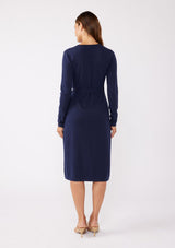 [Color: Navy] A brunette model wearing a sweater midi wrap dress in navy blue. Featuring a flattering v neckline, side tie closure, and long sleeves. A versatile cozy knit dress for the office or special occasions.  