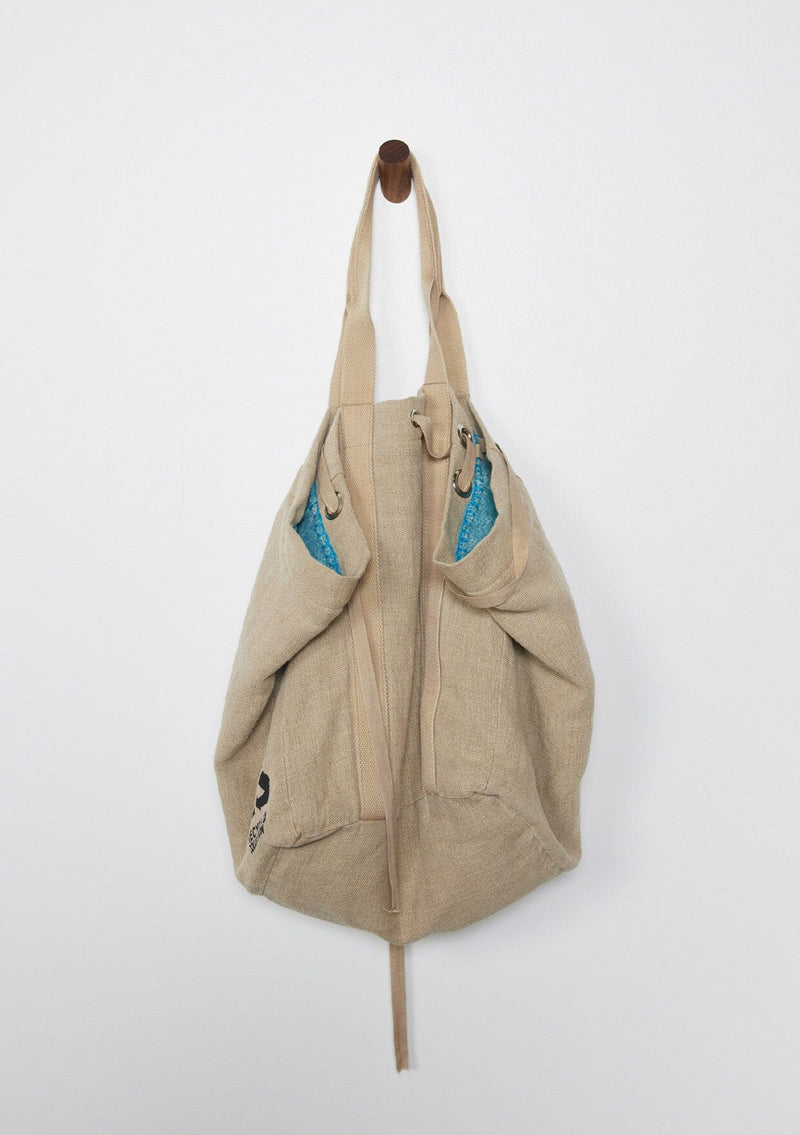 [Color: Natural/Blue/Sky] A reversible bohemian tote bag with double top handles, oversized grommets, an attached pouch with zip closure, and a tie closure. 