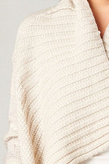 [Color: Grey/Ivory] A detailed image of a  beautiful chunky ivory knit cardigan with a shawl collar and ribbed detail. A western fall style waterfall cardigan with a cascading open front, long sleeves, and cozy side pockets. 