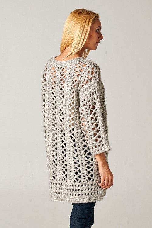 [Color: Light Grey] A model wearing an open knit crochet cardigan with 3/4 length sleeves, and a snap button front. 