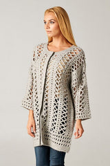 [Color: Light Grey] A model wearing an open knit crochet cardigan with 3/4 length sleeves, and a snap button front. 