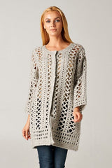 [Color: Light Grey] A model wearing an open knit crochet cardigan with 3/4 length sleeves, and a snap button front. 