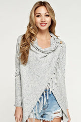 [Color: Blue/Vanilla] A blonde model wearing a blue and ivory speckled cardigan with a wrap front. Featuring a fringed hem, long sleeves, and a relaxed fit. 