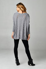 [Color: Grey/Black] A blonde model wearing a grey speckled cable knit pullover sweater with long dolman sleeves, a crew neckline, and a high low hemline. 