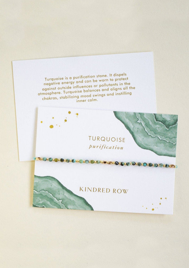 [Color: Turquoise] An adjustable healing bracelet, crafted on a durable nylon cord with gold-plated hardware and teal green gemstones. Designed by Kindred Row