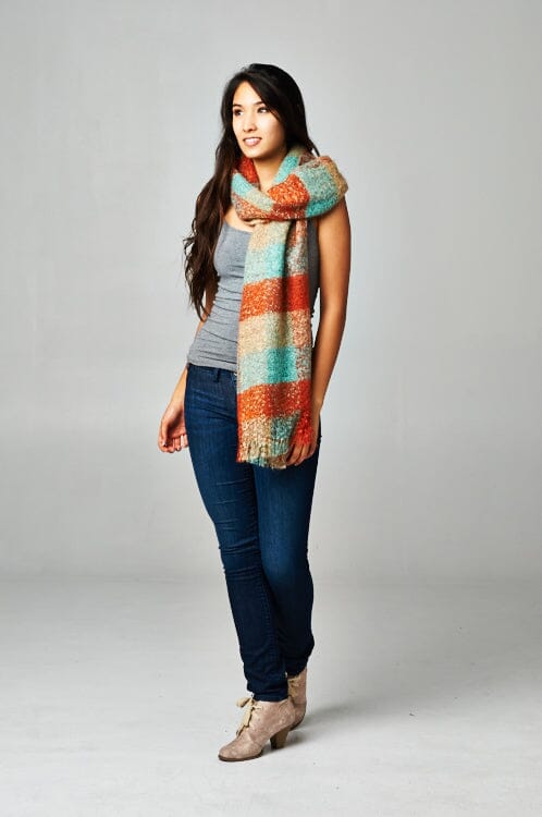 [Color: Orange/Seafoam/Beige] A brunette model wearing an orange and seafoam green plaid scarf with a fringed trim detail at the ends. Perfect for cozy layering and fall styling. 