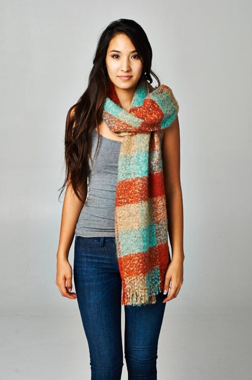 [Color: Orange/Seafoam/Beige] A brunette model wearing an orange and seafoam green plaid scarf with a fringed trim detail at the ends. Perfect for cozy layering and fall styling. 