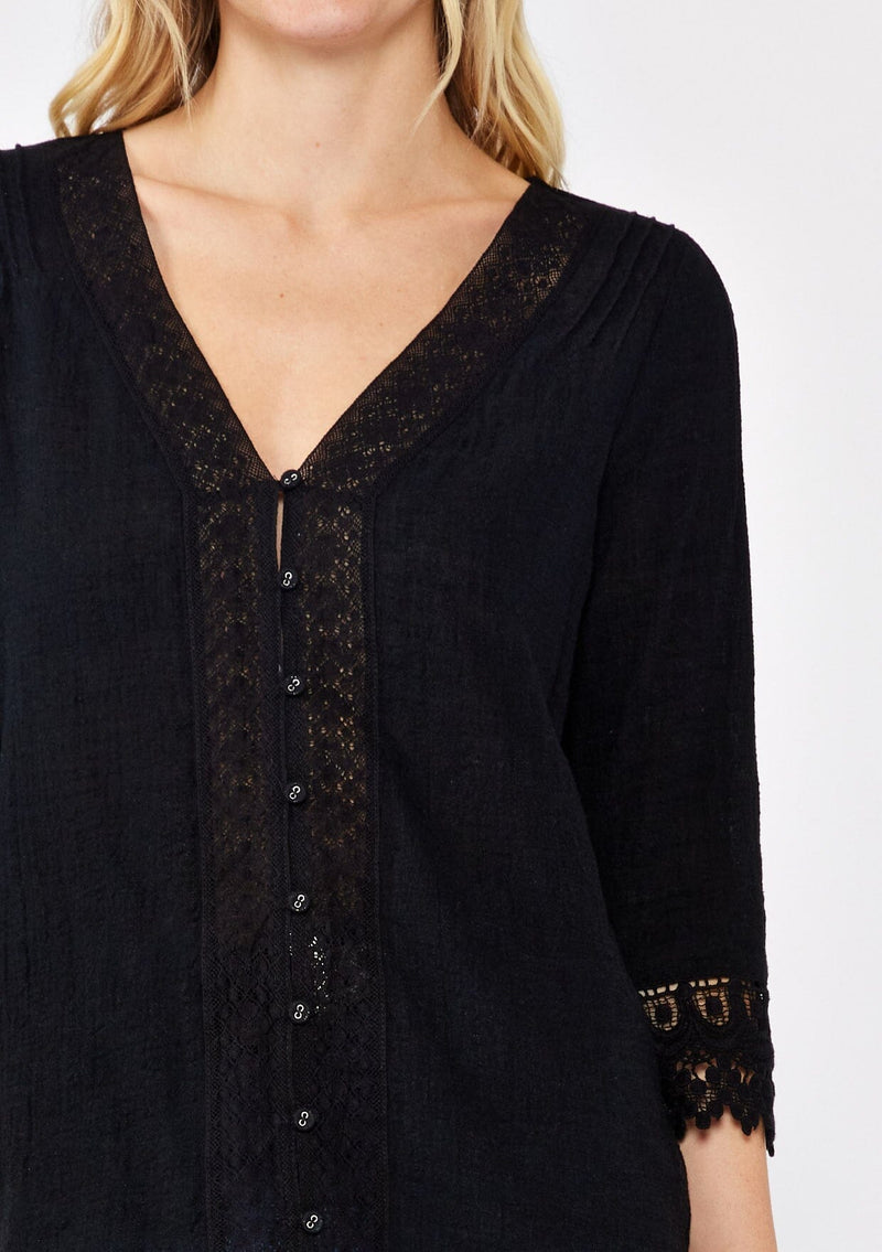 [Color: Black] A blonde model wearing a textured cotton blouse in black. With lace and crochet trims, functional button front, v neckline, and relaxed fit. A casual bohemian top paired with denim jeans.