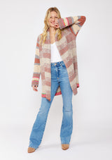 [Color: Natural/Dusty Clay] A blonde model wearing an ultra soft cardigan in a multicolor heather stripe knit. Featuring an open front, relaxed shawl collar, and cozy long sleeves. Paired and styled with vintage denim and boots for the ultimate fall look. 