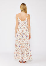 [Color: Natural/Rust] A blonde model wearing a flowy ultra bohemian maxi dress in a vintage ivory and dusty pink floral print. A relaxed fit dress with a tiered skirt, side pockets, scalloped v neckline, and adjustable spaghetti strap. A very breezy dress styled with bohemian strappy flats for a laid back look.