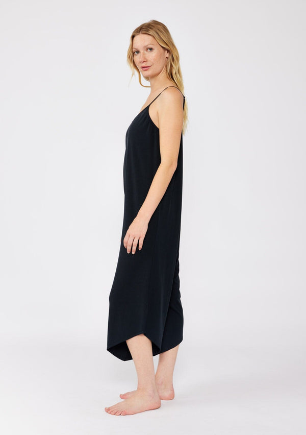 [Color: Black] A blonde model wearing an ultra soft knit jumpsuit with a cropped leg. A sleeveless black jumpsuit with a scoop neckline and adjustable spaghetti straps. A lounge jumpsuit designed with an oversized fit and stretchy fabric.