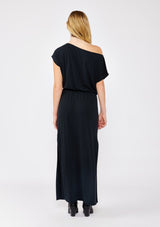 [Color: Black] A blonde model wearing a relaxed fit maxi that can be worn on or off shoulder. A casual black dress with a boat neckline, short dolman sleeves, elastic waistline, and side slits. Styled with black western boots for the fall season.