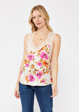 [Color: Natural/Orchid] A blonde model wearing a pretty lace trim cami tank top. A floral print tank with a v neckline, racerback, and  relaxed fit. Styled with dark denim jeans for the perfect fall look. 