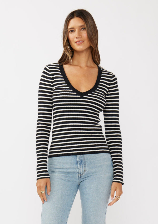 [Color: Black/White] A front facing image of a black and white striped pullover sweater with a ribbed texture, long sleeves, and a wide v-neckline. A timeless piece ideal for layering.