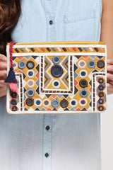 [Color: Mustard Multi] An image of a yellow embroidered clutch with a tassel zipper pull. 