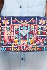 [Color: Multi] An image of a multi color cotton clutch with intricate embroidery and a tassel zipper pull. 