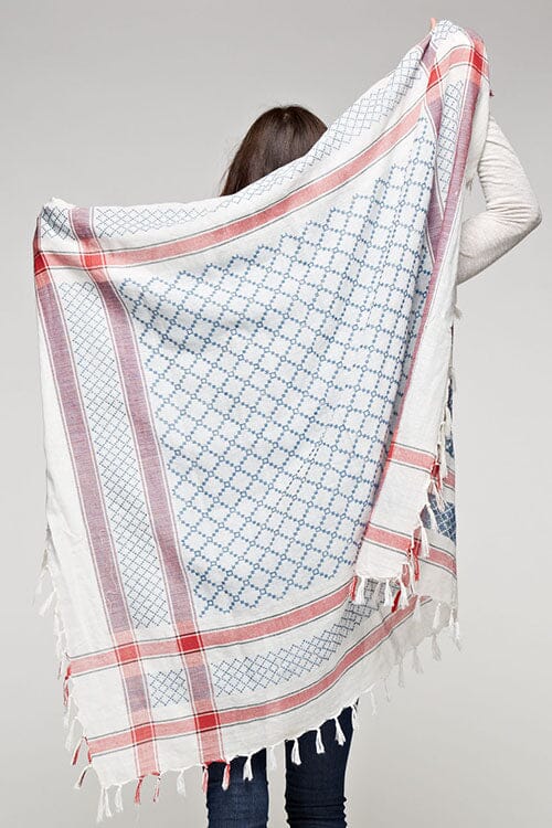 [Color: Natural/Blue/Red] A brunette model wearing a lightweight geometric pattern scarf with a striped border and fringed trim, adding a stylish touch to her look. Perfect for any season.