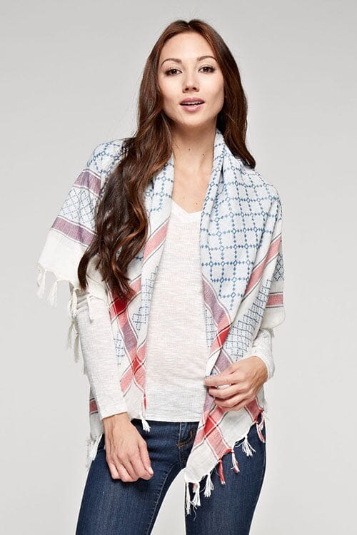 [Color: Natural/Blue/Red] A brunette model wearing a lightweight geometric pattern scarf with a striped border and fringed trim, adding a stylish touch to her look. Perfect for any season.