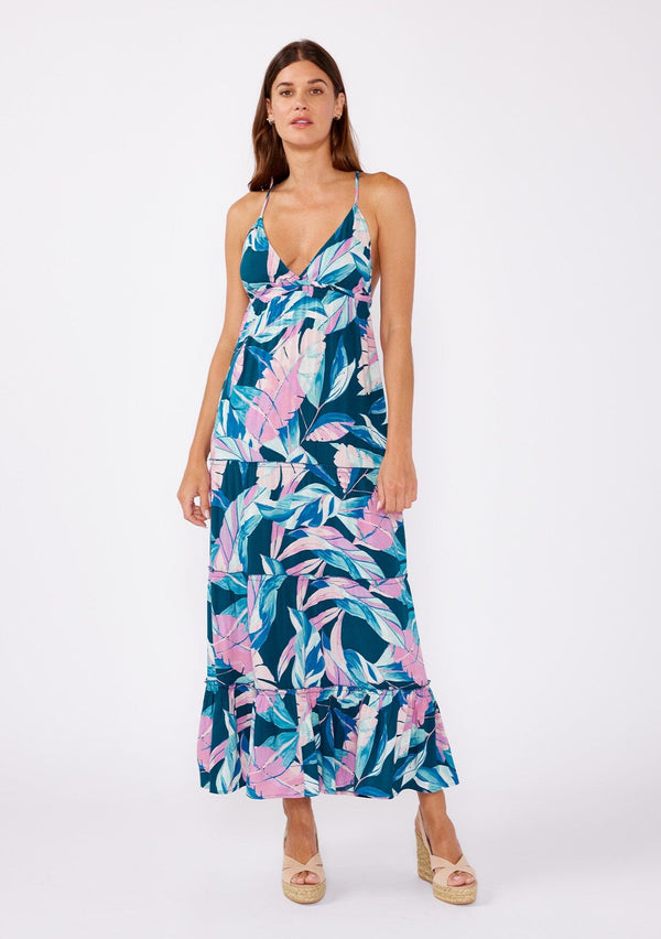 [Color: Teal/Dusty Orchid] A brunette model wearing a beautiful tropical print maxi dress with wedges. A tiered maxi dress with ruffle trim details, spaghetti straps, cross back, and v neckline. A vacation style dress with an empire waistline for a flowy fit. 