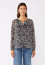 [Color: Black/Grey] A brunette model wearing a relaxed fit blouse in black and ivory floral print with shimmering metallic clip dot details. A classic, timeless blouse in a flowy chiffon with long sleeves and a button front. Perfect for the office or late night dinners.  