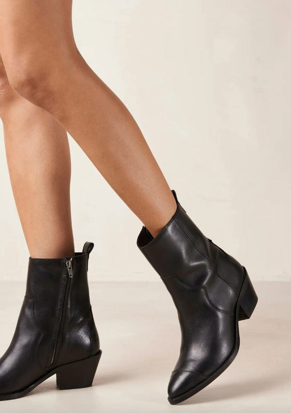[Color: Black] A black leather boot with a side zipper and small slanted block heel. Made in Portugal. Designed in Spain. 