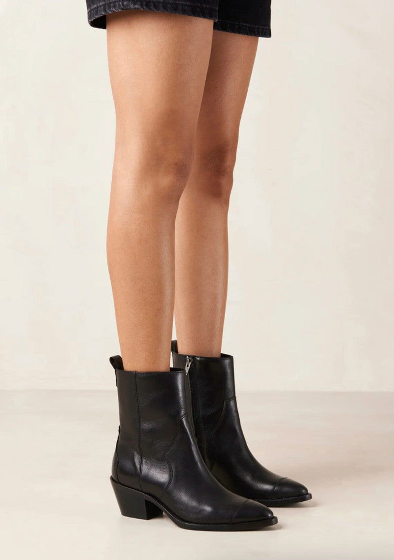 [Color: Black] A black leather boot with a side zipper and small slanted block heel. Made in Portugal. Designed in Spain. 