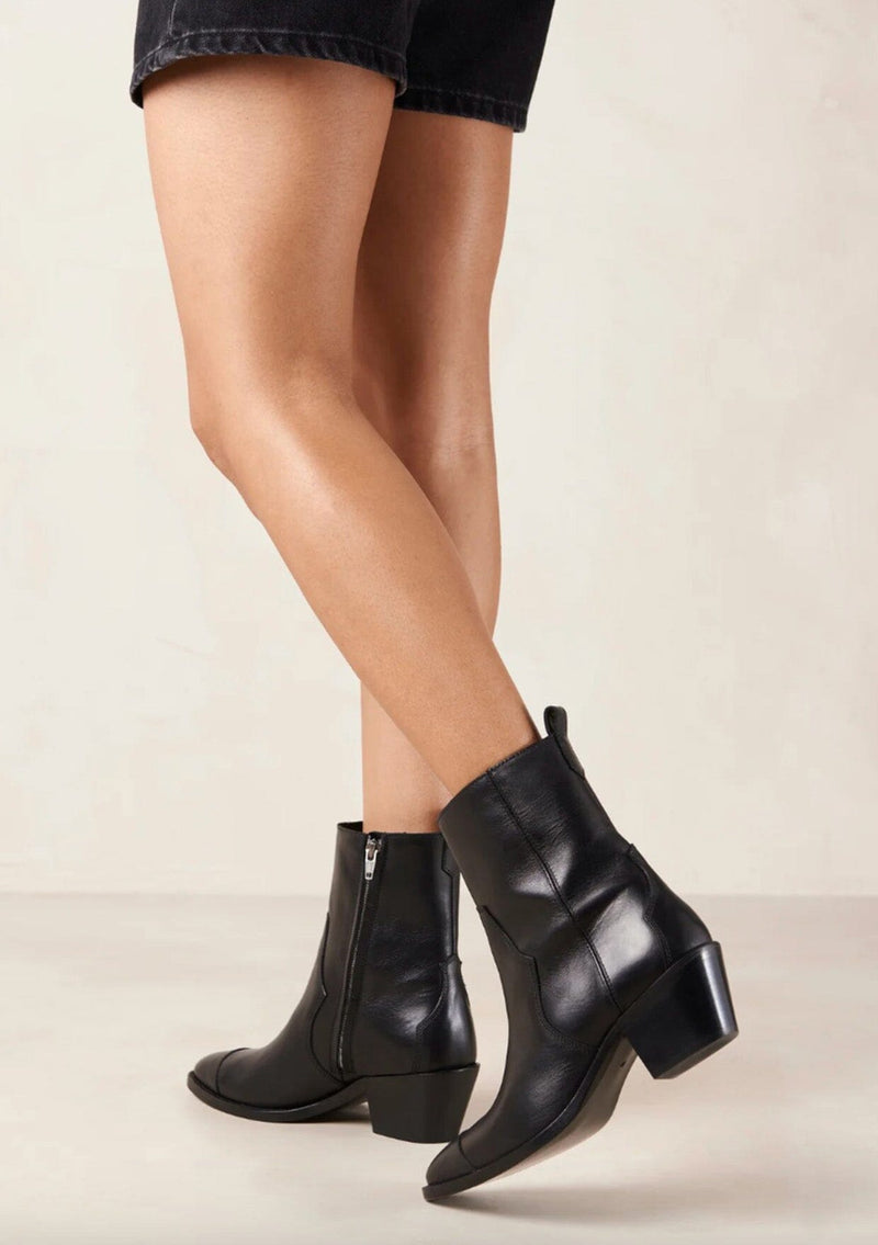 [Color: Black] A black leather boot with a side zipper and small slanted block heel. Made in Portugal. Designed in Spain. 