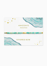 [Color: Amazonite] An adjustable healing bracelet, crafted on a durable nylon cord with gold-plated hardware and teal gemstones. Designed by Kindred Row.