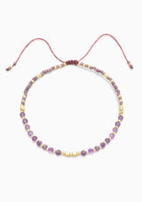 [Color: Amethyst] An adjustable healing bracelet, crafted on a durable nylon cord with gold-plated hardware and purple natural gemstones. Designed by Kindred Row.