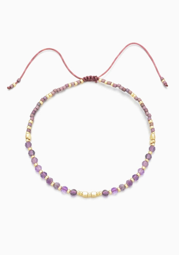 [Color: Amethyst] An adjustable healing bracelet, crafted on a durable nylon cord with gold-plated hardware and purple natural gemstones. Designed by Kindred Row.