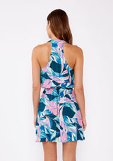 [Color: Teal/Dusty Orchid] A brunette model wearing a tropical leaf print sleeveless mini dress with a surplice v neckline and racerback. A lightweight mini dress with a vibrant print perfect for vacation and casual outings.