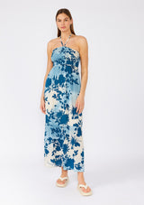 [Color: Navy/Dusty Blue] A front facing image of a brunette model wearing a dreamy bohemian halter maxi dress in a blue floral print. With a smocked elastic slim fit bodice, a long ruffles trimmed tiered skirt, and an adjustable halter tie neckline. 