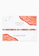 [Color: Carnelian] An adjustable healing bracelet, crafted on a durable nylon cord with gold-plated hardware and red orange gemstones. Designed by Kindred Row.