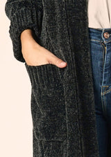 [Color: Forest] A close up front facing image of a brunette model wearing a soft forest green chenille knit duster cardigan. With long sleeves, an open front, and side pockets. 