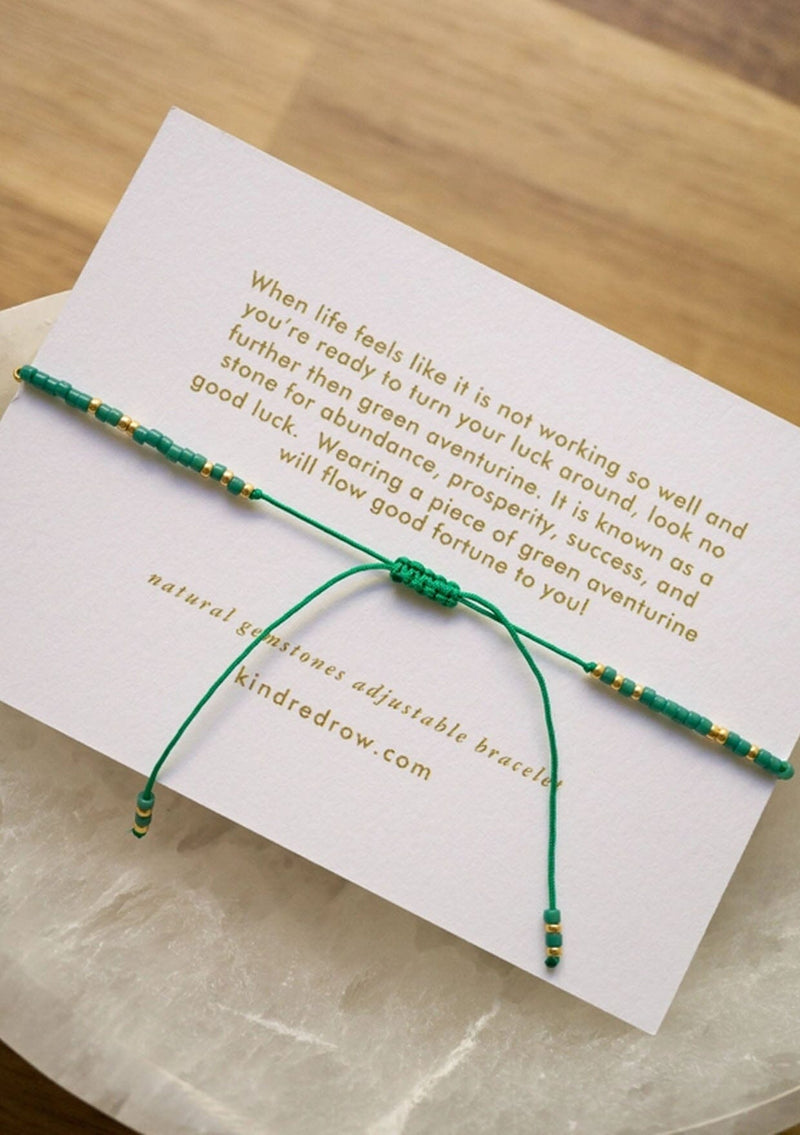 [Color: Green Aventurine] An adjustable healing bracelet, crafted on a durable nylon cord with gold-plated hardware and green natural gemstones. Designed by Kindred Row.