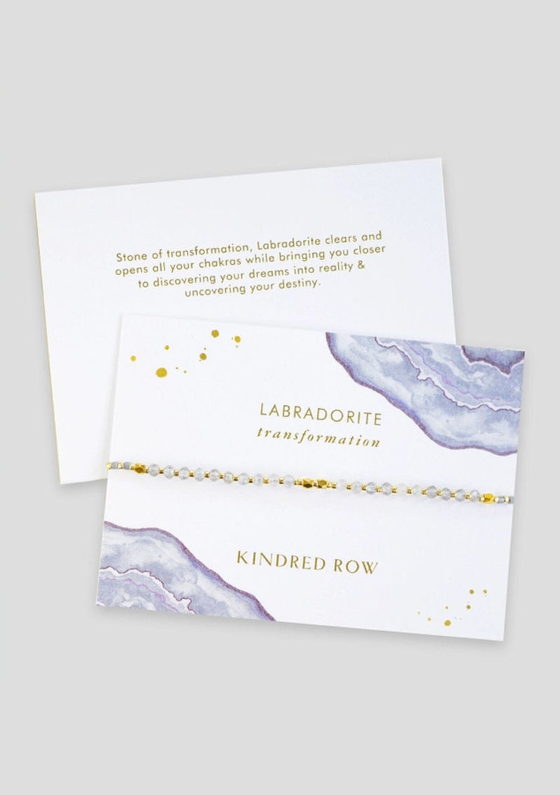 [Color: Labradorite] An adjustable healing bracelet, crafted on a durable nylon cord with gold-plated hardware and clear grey natural gemstones. Designed by Kindred Row.