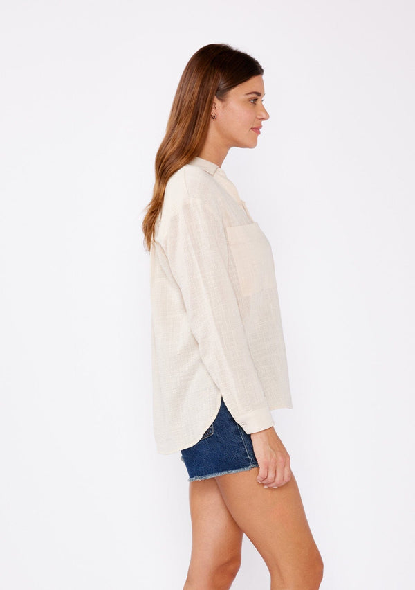 [Color: Sand] A relaxed fit blouse crafted from breathable textured cotton fabric. Features a collared neckline, lace up front, and long sleeves with button cuff closures. A daytime casual top for beach outings or running errands.