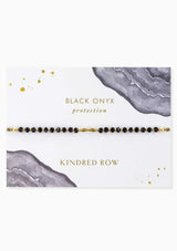 [Color: Onyx] An adjustable healing bracelet, crafted on a durable nylon cord with gold-plated hardware and black natural gemstones. Designed by Kindred Row.