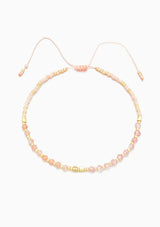 [Color: Rose Quartz] An adjustable healing bracelet, crafted on a durable nylon cord with gold-plated hardware and pink natural gemstones. Designed by Kindred Row.