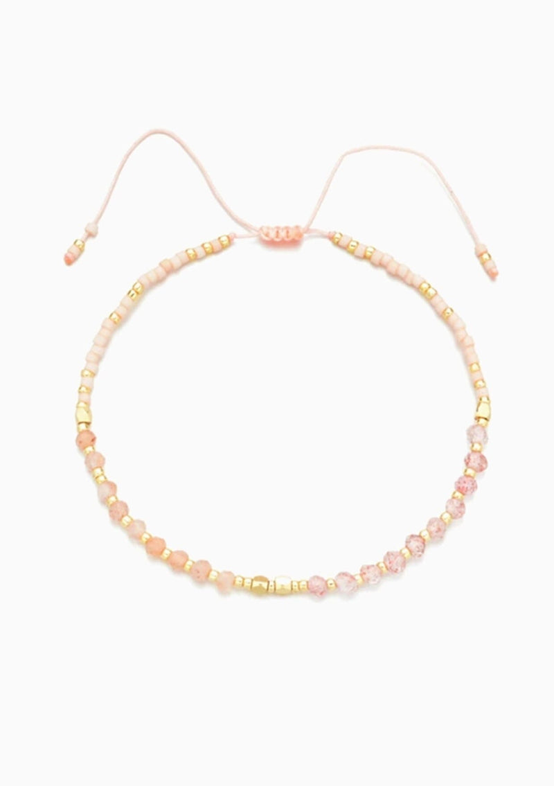 [Color: Rose Quartz] An adjustable healing bracelet, crafted on a durable nylon cord with gold-plated hardware and pink natural gemstones. Designed by Kindred Row.