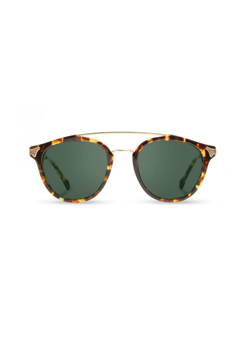 [Color: Dark Speckle] Clear Italian acetate sunglasses with contemporary round lens, metal brow bar, and wood accents. Framed with a tortoise, yellow and brown pattern.