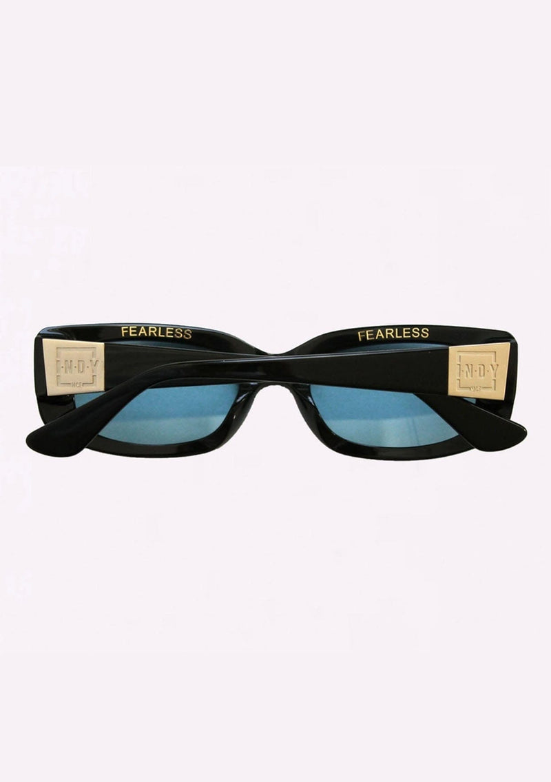 [Color: Sky] A classic rounded rectangular frame in a black frame made with biodegradable acetate. With polarized sky blue lenses and the word fearless on the inner frame.