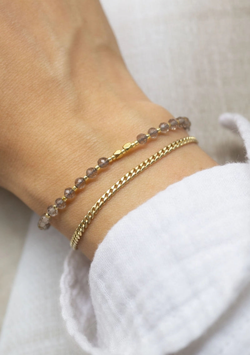 [Color: Smoky Quartz] An adjustable healing bracelet, crafted on a durable nylon cord with gold-plated hardware and colorless gemstones. Designed by Kindred Row