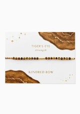 [Color: Tiger's Eye] An adjustable healing bracelet, crafted on a durable nylon cord with gold-plated hardware and brown gemstones. Designed by Kindred Row.